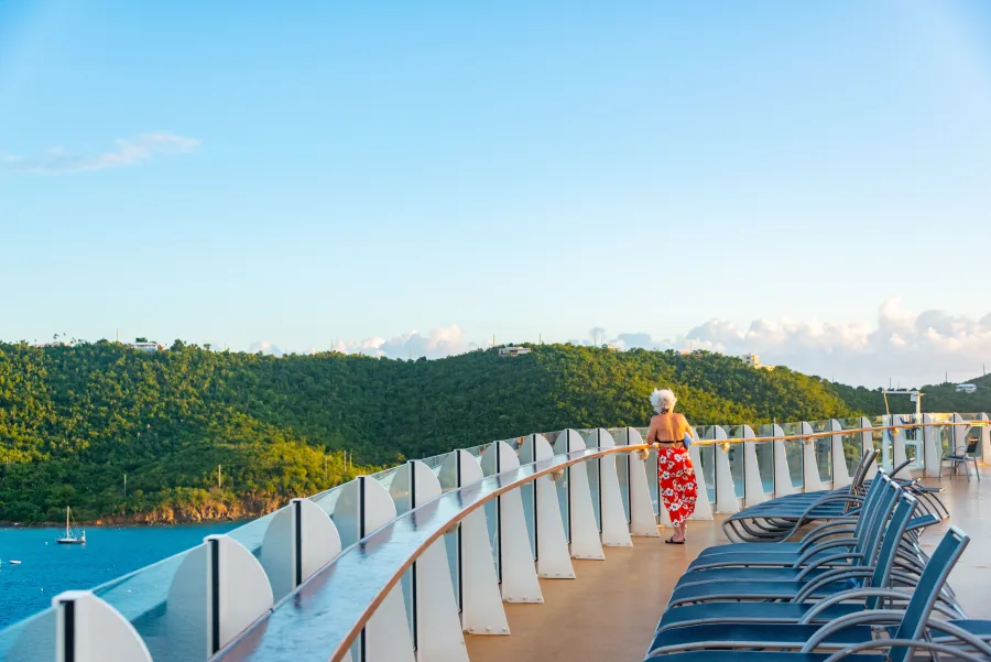 A woman taking in the view from the deck of a cruise ship